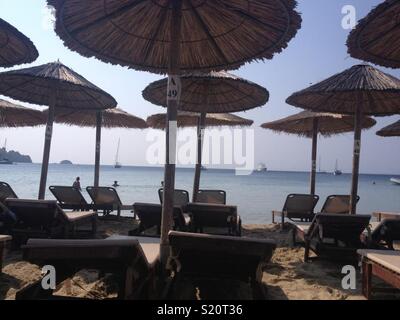 Des chaises longues sur la plage grecque Banque D'Images