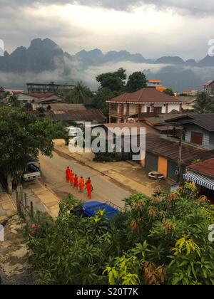 La marche des moines au temple tôt le matin dans la région de Vang Vieng Laos Banque D'Images