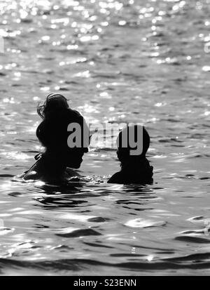 Mère et bébé dans la silhouette de la mer Banque D'Images