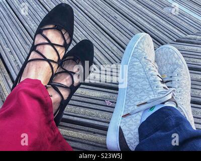 Deux paires de pieds des femmes portant des différents styles de chaussure. Banque D'Images