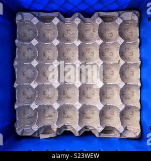 Boîte à œufs carrés vides sur le bas de caisse de lait en plastique bleu Banque D'Images