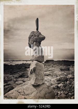 La pierre naturelle/rock sculpture d'équilibrage sur la plage avec des vagues. Banque D'Images