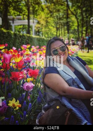 Une dame pose pour une photo dans un jardin. Banque D'Images