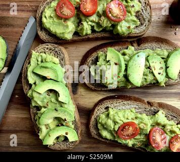 Vue de dessus de l'avocat toast sur une planche à découper en bois Banque D'Images
