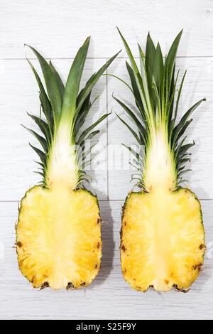 Un ananas frais et de fruits tropicaux coupé en deux sur un fond blanc Banque D'Images