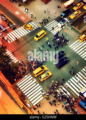Les spectateurs l'affichage de la coucher du soleil directement en bas de la rue à Midtown Manhattan, Manhattanhenge ou canyon de lumière, NYC, USA Banque D'Images