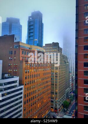 L'Empire State building enveloppé dans le brouillard le long de 34th Street à Manhattan, New York, USA Banque D'Images