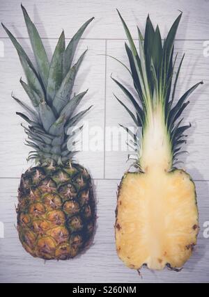 Un ananas frais coupé en deux sur un fond blanc Banque D'Images