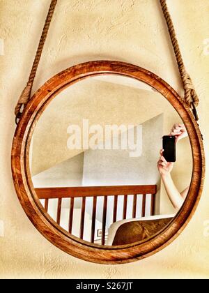 Personne en tenant les mains de selfies dans un miroir rond d'un balcon Banque D'Images