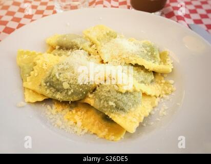 Une recette typique de la cuisine italienne : emilian tortelli farci aux épinards et ricotta et couverts de fromage parmesan Banque D'Images