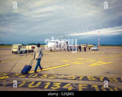 Quelques passagers sur le tarmac de l'avion pour embarquer sur le matin tôt. Banque D'Images