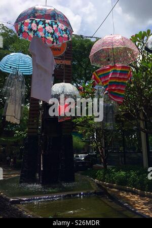 Parasols colorés et des vêtements féminins en suspension dans l'air au-dessus de l'eau courante Banque D'Images