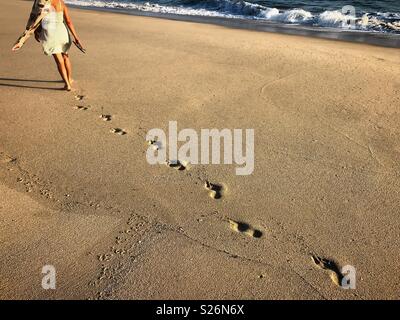 Une femme entre dans la plage dans la côte du Pacifique à Todos Santos, Baja California, Mexique Banque D'Images