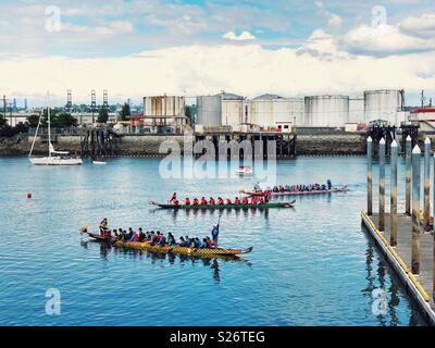 Les bateaux-dragons colorés en course Thea Foss waterway de Tacoma, WA, à côté de la zone industrielle Banque D'Images