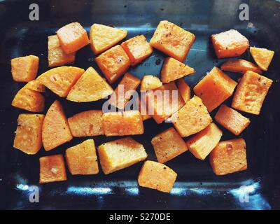 Rôti au four et assaisonné de courge Butternut coupé en cubes dans un plat de cuisson en verre Banque D'Images