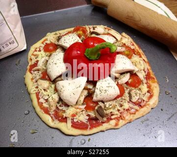 Pizza fait maison sur une plaque de cuisson avec poivron rouge et des champignons. Banque D'Images