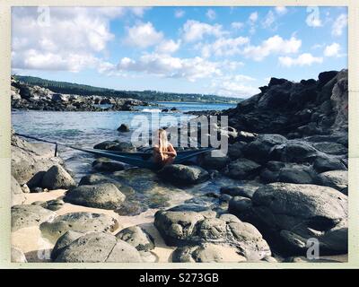 Ma douce sirène ami assis dans un hamac suspendu au-dessus les mares. Honolua Bay, Maui. Banque D'Images