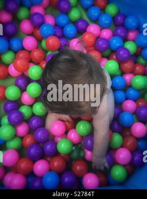 Baby boy playing in ball pit Banque D'Images