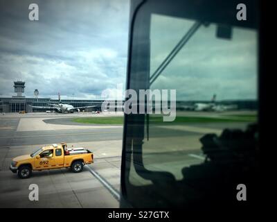 Sterling, Virginie, USA - 27 juin 2018 : un véhicule terrestre passe par un passager en tenant salon mobile des passagers des compagnies aériennes d'un milieu de terminal de l'Aéroport Washington Dulles International Airport. Banque D'Images