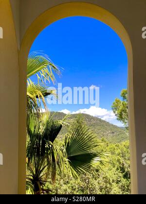 Vue à travers une fenêtre en arc sur le ciel bleu et le beau paysage Banque D'Images