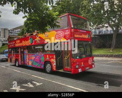 Les touristes sur un Hop On Hop Off, rouge, couleur vive, double decker bus London open top, Funchal, Madeira, Portugal Banque D'Images