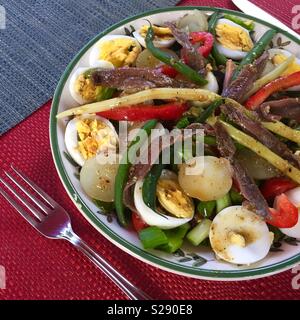 Salade niçoise - salade verte, tomates, pommes de terre nouvelles, haricots verts, anchois, oeufs, olives et vinaigre balsamique. Une salade saine et savoureuse Banque D'Images