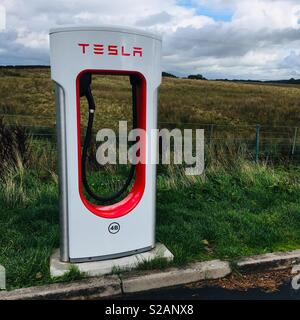 Chargeur de voiture électrique Tesla dans la campagne anglaise. Banque D'Images