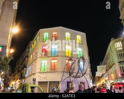 Un bâtiment éclairé par des fenêtres pleine avec toute une gamme d'éclairage de couleur. Banque D'Images