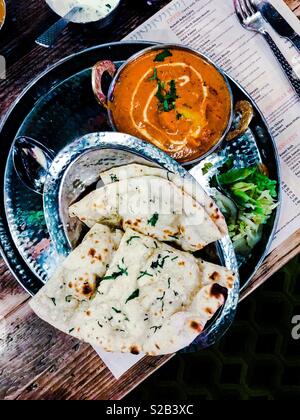 Le sud de l'Indian curry de poulet beurre à l'ail pain naan on silver platter Banque D'Images