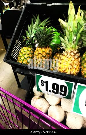 Shopping pour les fruits - une bande d'ananas jaune vif sur l'écran et oignons blancs - : comme annoncé et panier à l'isle Banque D'Images