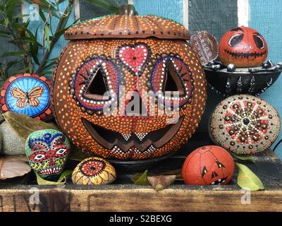 Un affichage de l'Halloween et l'automne avec l'oeuvre un terra-cotta jack o lantern et un peu de sucre des crânes et des roches dans Mandala des couleurs de saison. Banque D'Images
