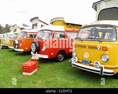 Rouge orange et jaune campervans VW Volkswagen à un show Banque D'Images