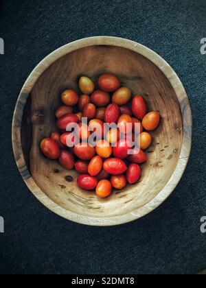 Des tomates cerise dans un bol en bois faits à la main Banque D'Images