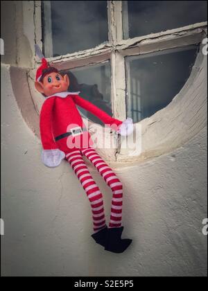 Naughty elf assis sur un rebord de fenêtre. Banque D'Images