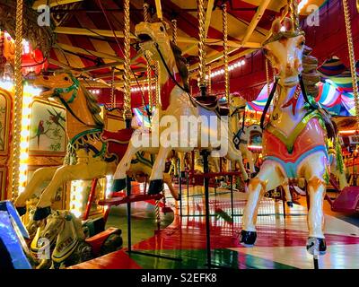 Trois chevaux du carrousel de foire sur le vintage ride at Dingles Parc d'Heritage Centre. Banque D'Images