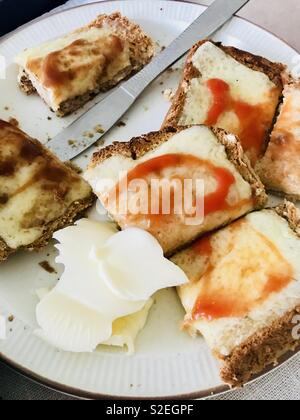 Fromage sur pain grillé avec sauce rouge et marron avec une noix de beurre Banque D'Images