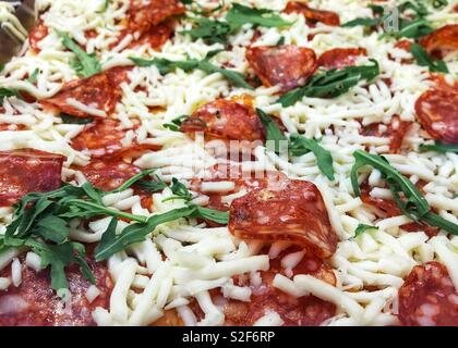 Pizza au pepperoni, avec des feuilles de roquette Banque D'Images
