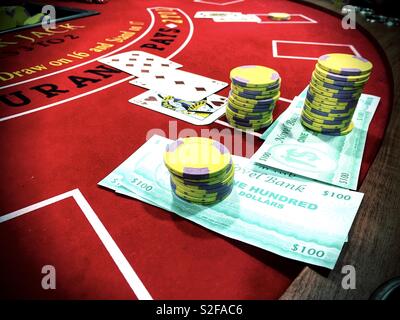 Jetons. prétendre l'argent et les cartes à jouer sur une table de blackjack. Banque D'Images