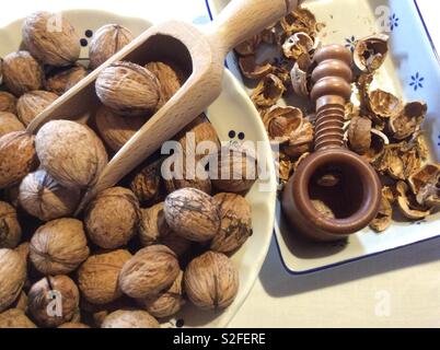 Coquilles de noix, récoltés et un sol en bois Casse-noisette et chute dans des plats en céramique vintage Banque D'Images