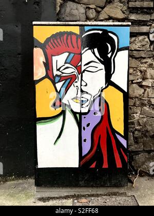 Street art sur un central téléphonique fort à Dublin en Irlande, représentant les chanteurs pop Ziggy Stardust alias David Bowie et Prince. Banque D'Images