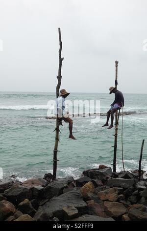 Deux traditionnelles mais fatigué échasses cinghalaise Fisher, à la côte du Sri Lanka, de l'océan indien Banque D'Images