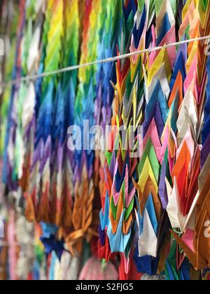 Une offre de 100 grues de papier plié sur une chaîne dans un temple japonais. Banque D'Images