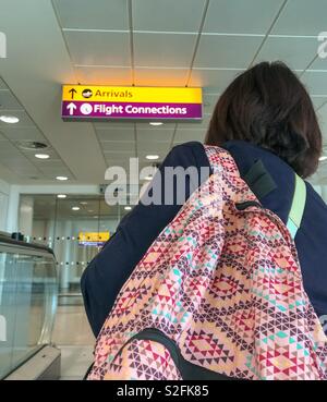 Sac à dos avec personne arrivant dans un terminal de l'aéroport après son avion Banque D'Images