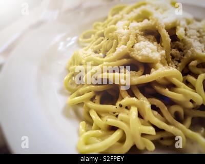 Gros plan d'une portion de pâtes spaghetti italien avec fromage et sauce au piment Banque D'Images