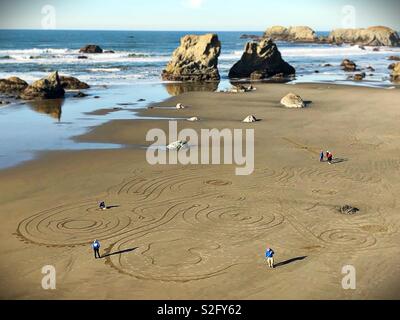 Les artistes de la création d'un labyrinthe de sable sur la plage en face Rock Bandon, Oregon, USA. Banque D'Images