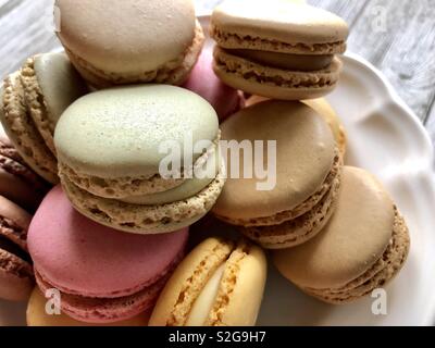 Macarons pastels sur une plaque blanche Banque D'Images