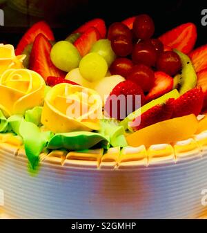 Gâteau de décoration chinois avec des roses jaunes et de fruits frais. Banque D'Images