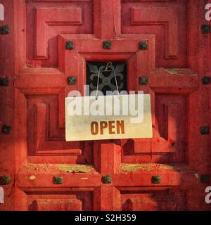 Open sign sur une porte en bois rouge Banque D'Images