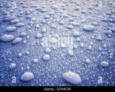 Taches de pluie gelée sur un pare-brise de voiture glacée. Banque D'Images