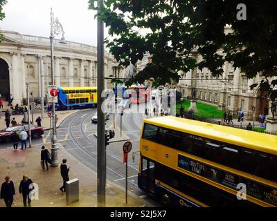 À la recherche vers le bas sur une rue passante ou road dans le centre-ville de Dublin avec les bus et les gens ou les piétons sur les trottoirs Banque D'Images